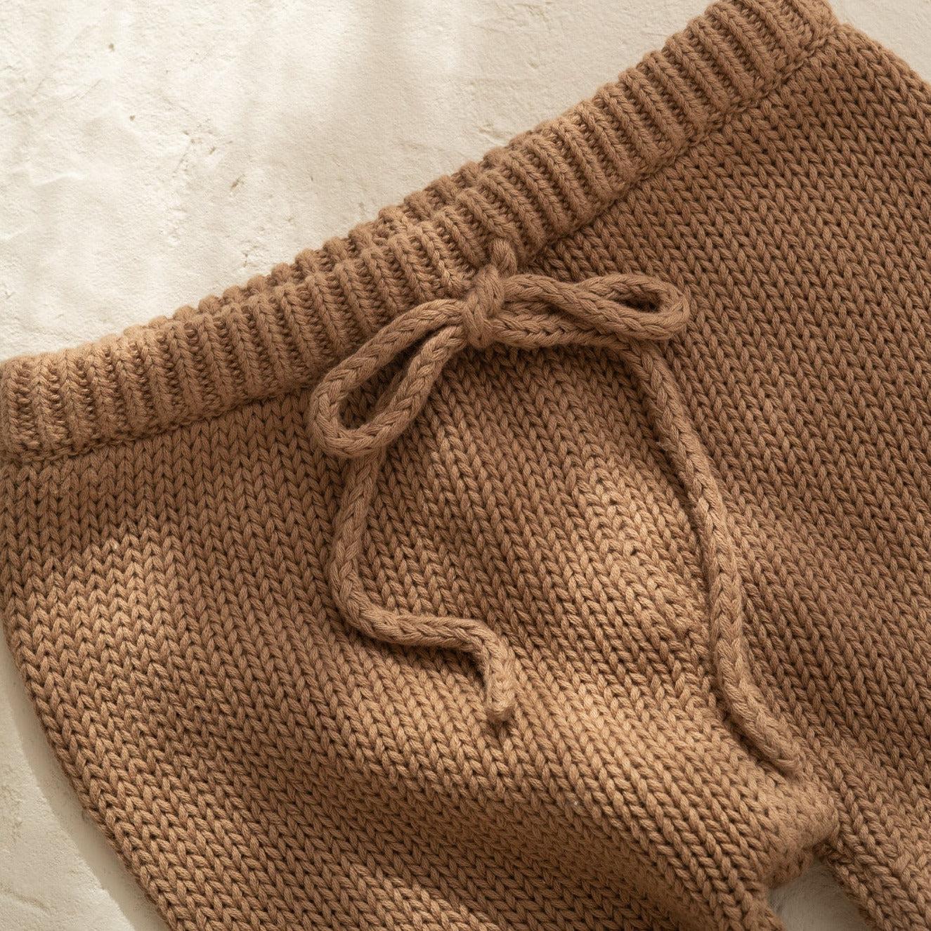 A close up of Illoura the Label's "illoura poet pants" in chocolate color.