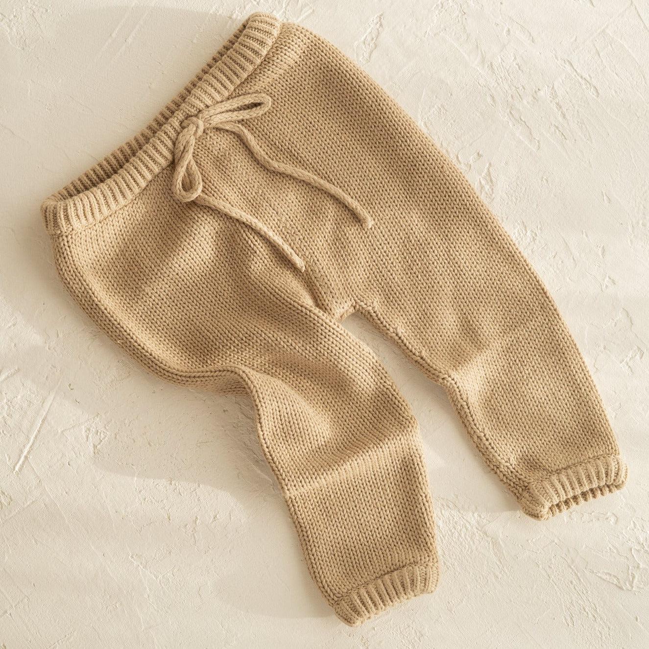A pair of illoura poet pants | olive by Illoura the Label on a white surface.