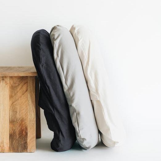 Three Snuggle Me Lounger Covers sitting against a wooden table.