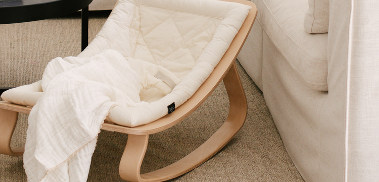 A white rocking chair in a living room.