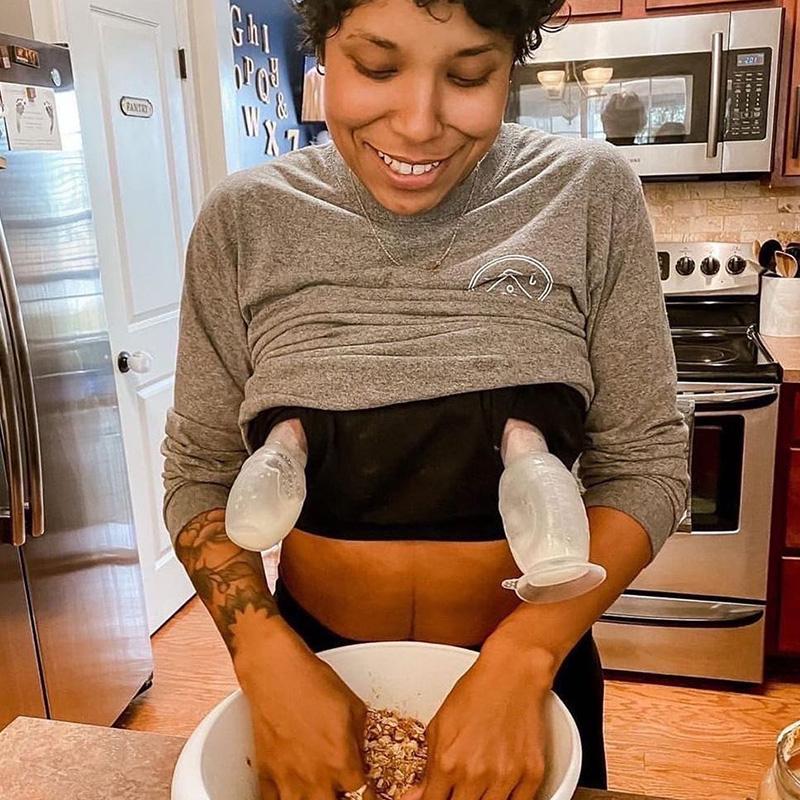 A woman preparing a bowl of food in a kitchen using the Haakaa Silicone Breast Pump 150ml Gen 2 by Haakaa.