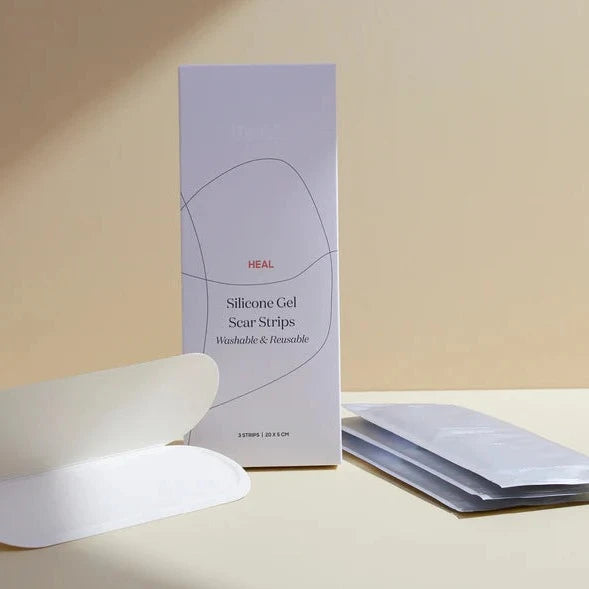 A box labeled "Bare Mum Silicone Gel Scar Strips" beside curved white gel strips and their packaging, set against a beige background.