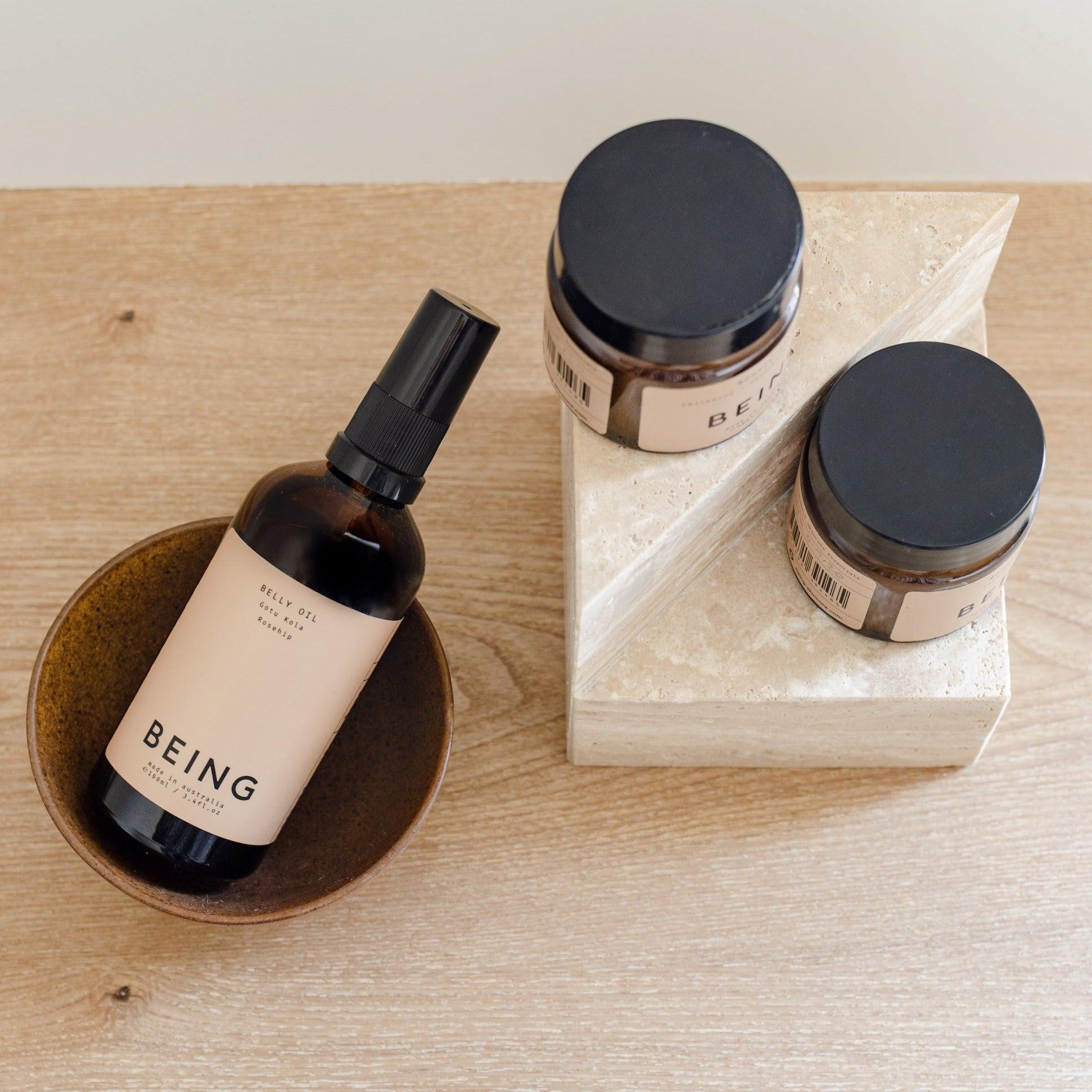 A mama & babe complete set from Being Skincare, including a bottle and bowl, displayed on a wooden table.