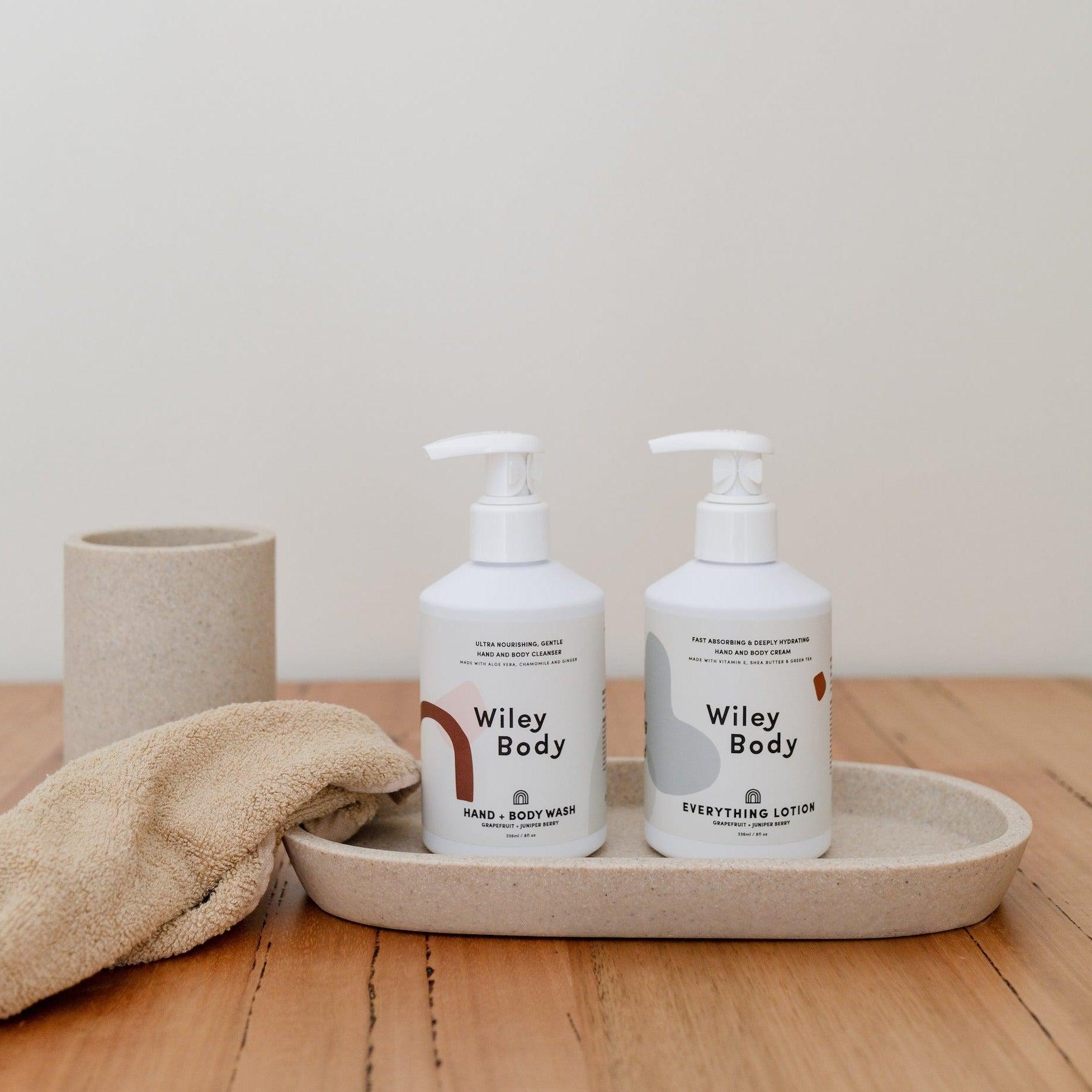 An organic aloe vera tray with a bottle of Wiley Body Hand & Body Wash and a towel.