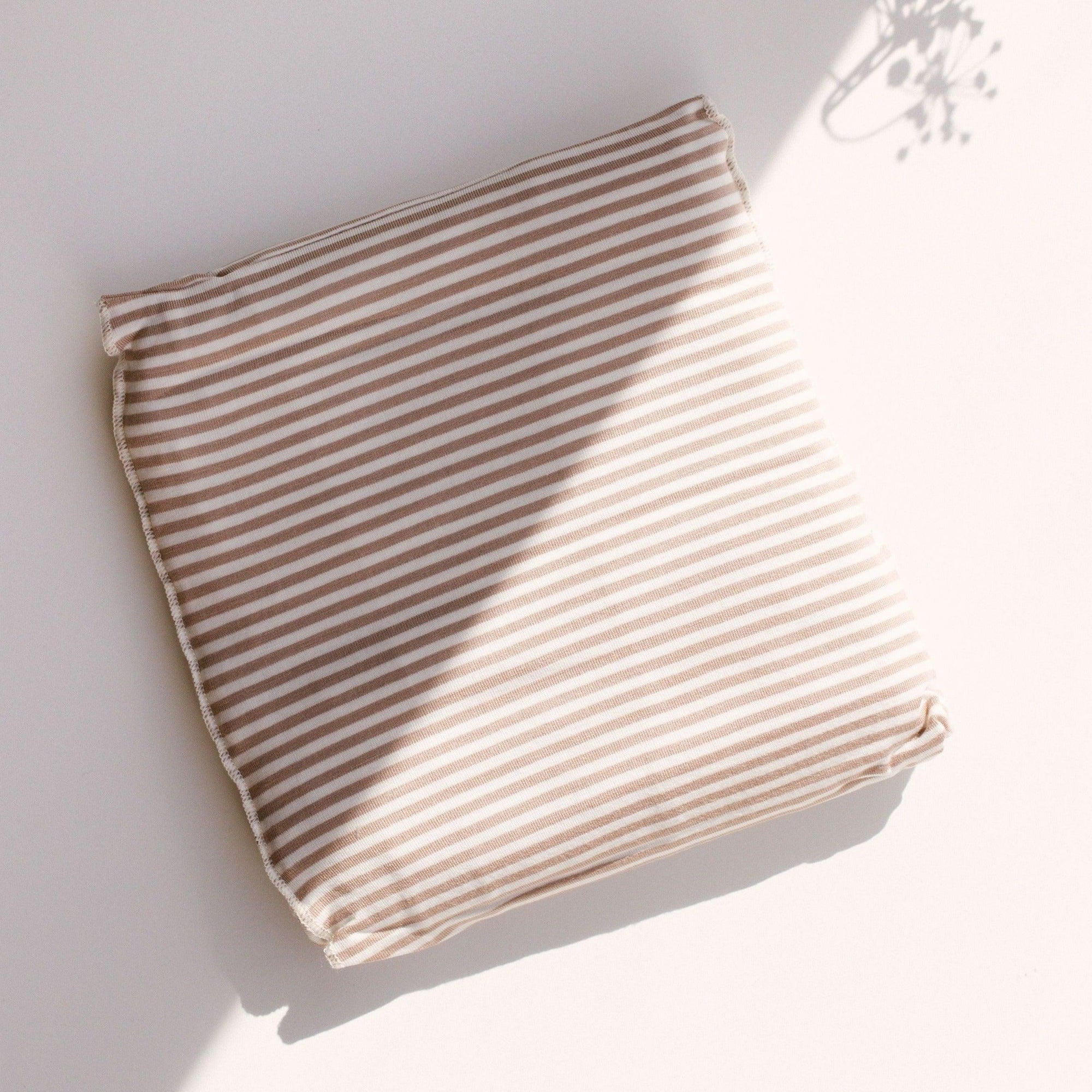A Cinta Stripe Wrap by Chekoh on a white surface.