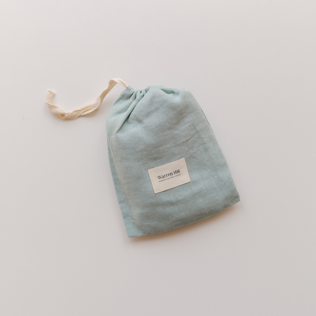 A blue Warren Hill linen bag with a label on it, perfect for neutral nursery style.